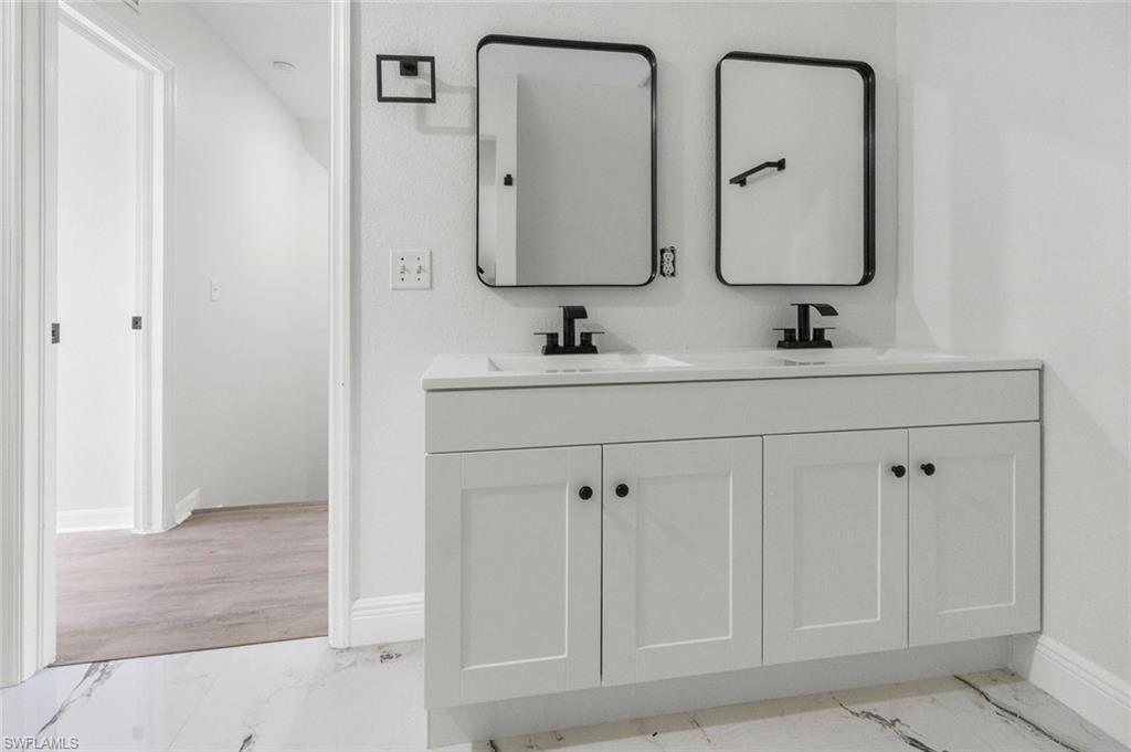 Undisclosed Address Naples, FL 34113 - Photo 6 of 21 a bathroom with double vanity sinks and a mirror