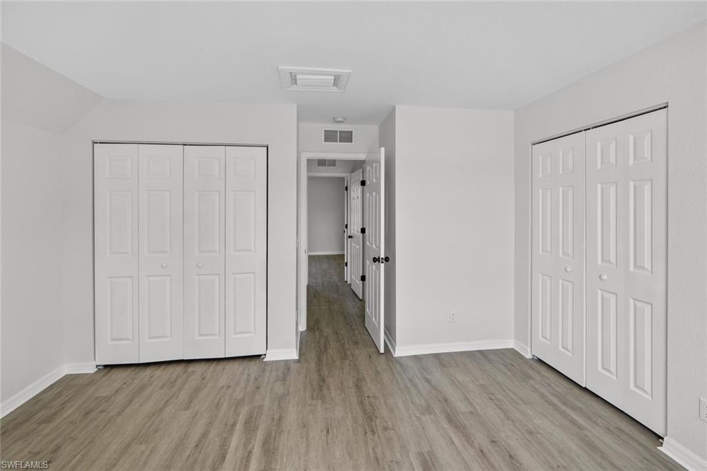 Undisclosed Address Naples, FL 34113 - Photo 8 of 21 a view of an empty room with wooden floor and a window
