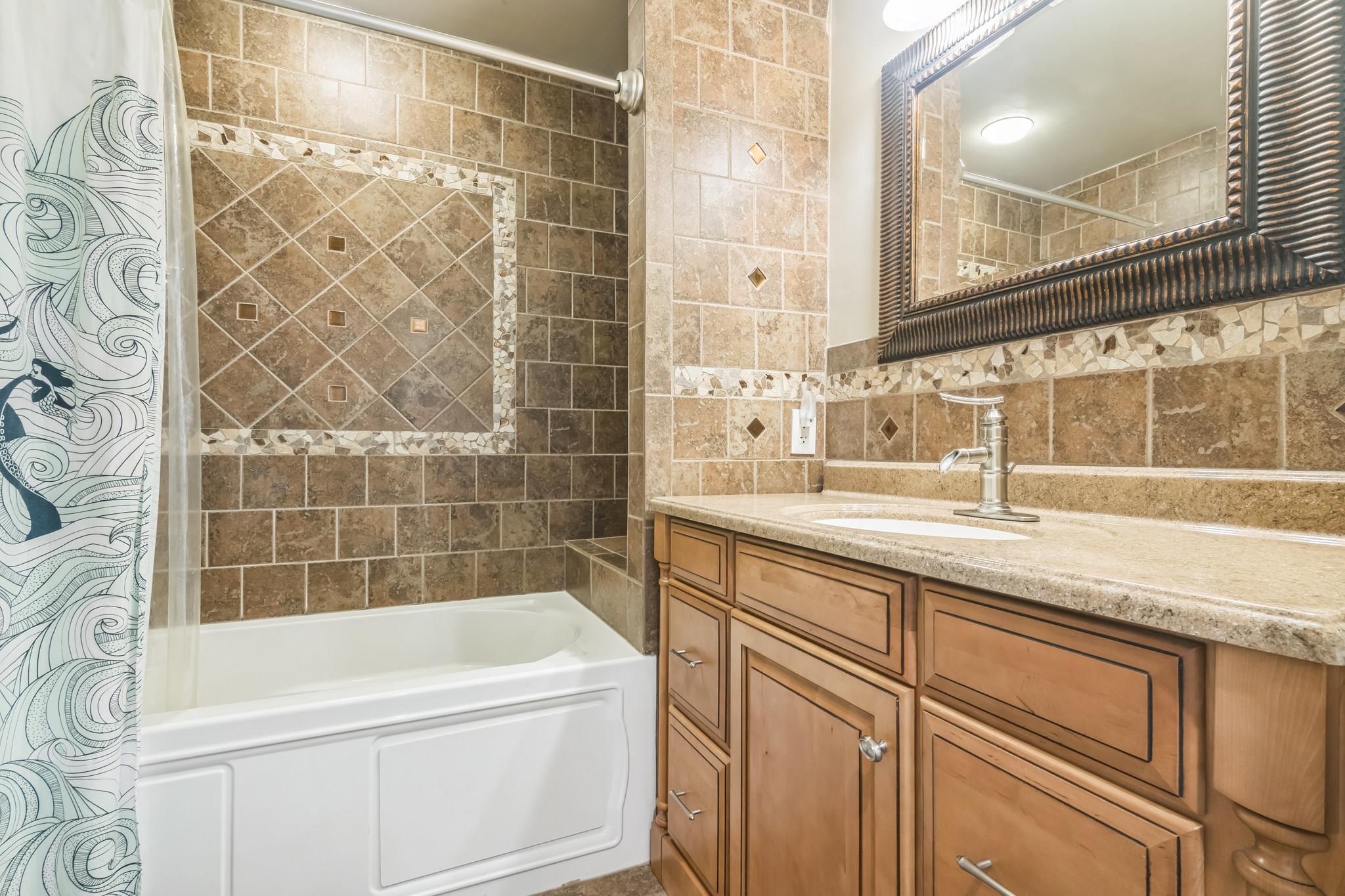 1504 Central, Unit 1504 Ocean City, NJ 08330 - Photo 13 of 16 a bathroom with a granite countertop sink mirror and a bathtub