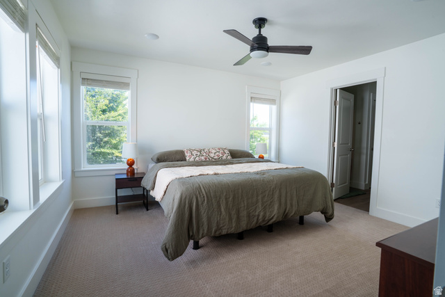 1486 West 2055th Street South Logan, UT 84339 - Photo 17 of 45 Carpeted room featuring multiple windows with blinds, a ceiling fan with light fixture, and a white interior door