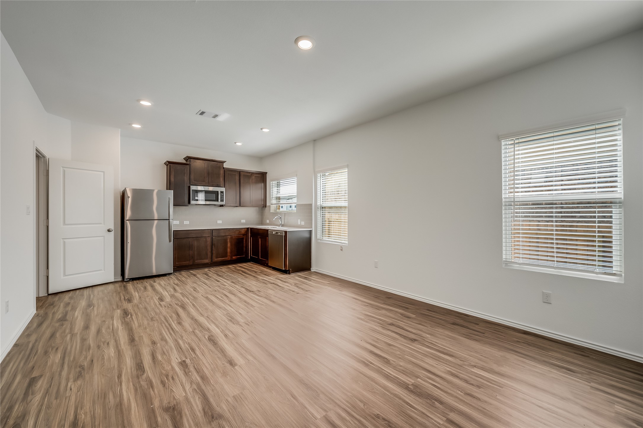 932 Mallow Road Leander, TX 78641 - Photo 28 of 40 Open-concept living space featuring wood-finish flooring, recessed lighting, and white walls