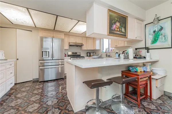 a kitchen with stainless steel appliances a refrigerator and a stove top oven