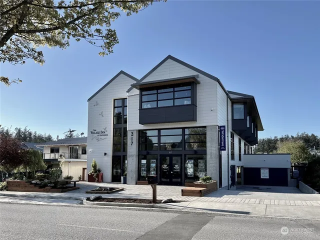a view of a brick building with a large tree
