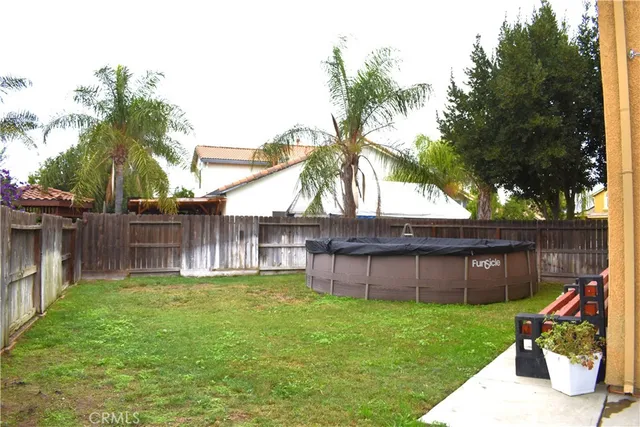 a backyard of a house with barbeque oven and floor to ceiling window