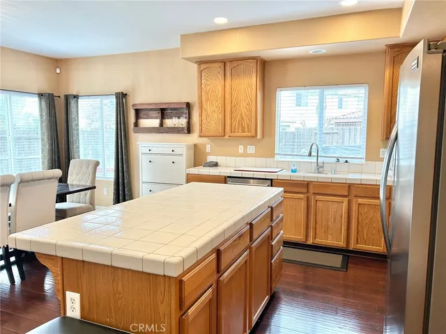 a kitchen with stainless steel appliances kitchen island a table chairs in it and a window