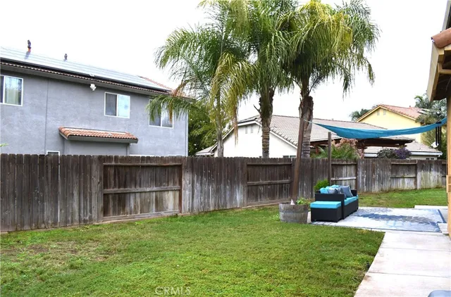 a backyard of a house with wooden floor and fence