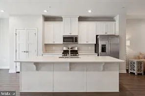 a kitchen with kitchen island a sink stainless steel appliances and cabinets