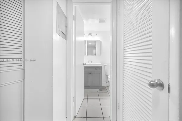 a view of a hallway with a white cabinet and a mirror