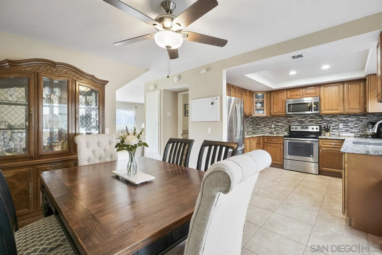 231 Blossom Way Oceanside, CA 92058 - Photo 12 of 31 a view of a dining room with furniture a chandelier and large windows