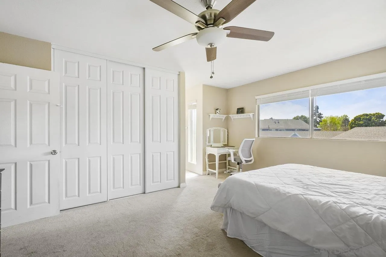 231 Blossom Way Oceanside, CA 92058 - Photo 14 of 31 a bedroom with a large bed and a chandelier fan