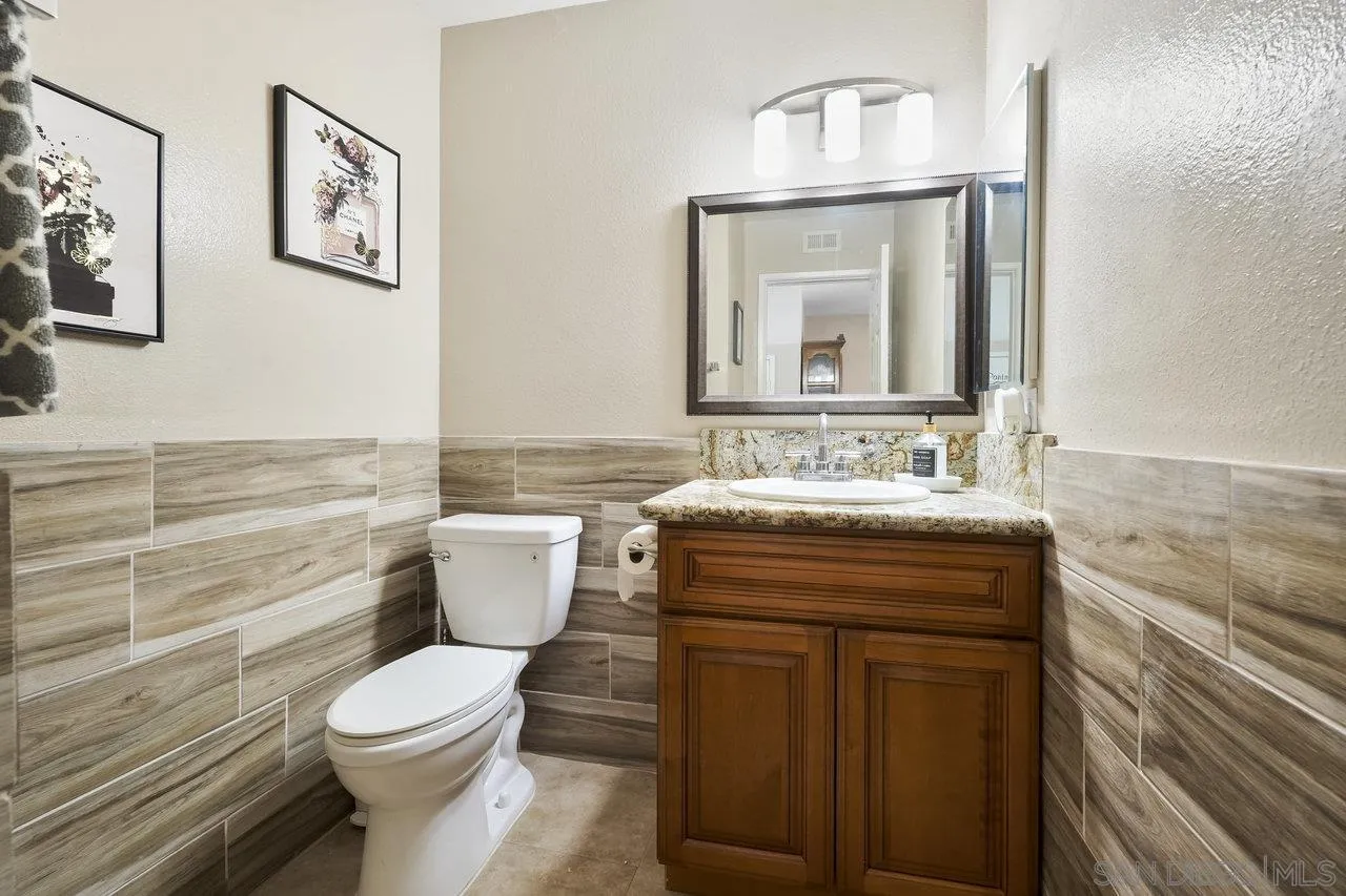 231 Blossom Way Oceanside, CA 92058 - Photo 22 of 31 a bathroom with a toilet a sink and a mirror