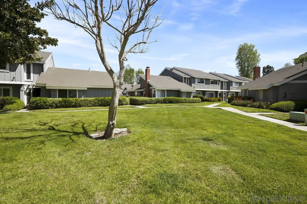 231 Blossom Way Oceanside, CA 92058 - Photo 31 of 31 a view of a white house with a big yard and potted plants and large trees
