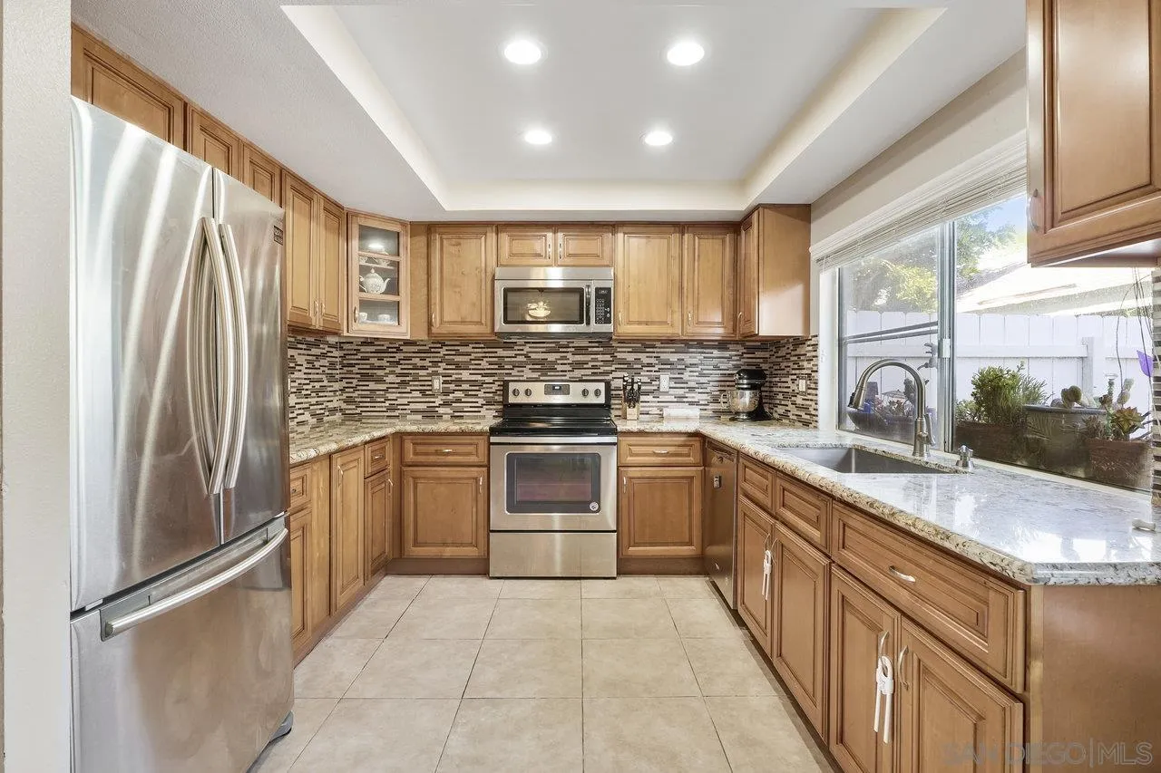 231 Blossom Way Oceanside, CA 92058 - Photo 8 of 31 a kitchen with stainless steel appliances granite countertop a refrigerator sink and stove