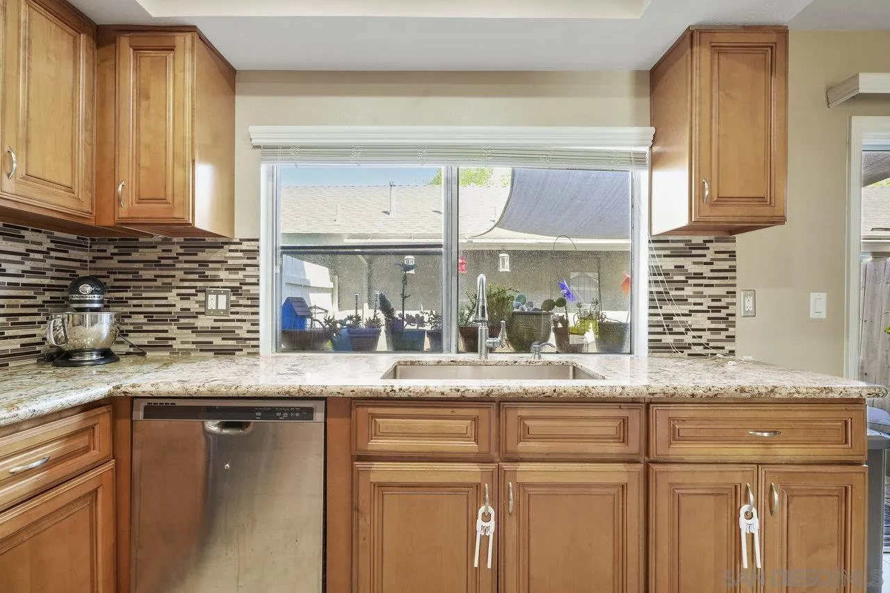 231 Blossom Way Oceanside, CA 92058 - Photo 9 of 31 a kitchen with granite countertop stainless steel appliances a sink and cabinets
