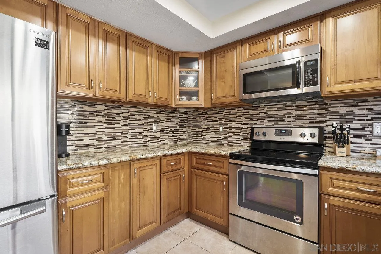 231 Blossom Way Oceanside, CA 92058 - Photo 10 of 31 a kitchen with granite countertop cabinets stainless steel appliances and a sink