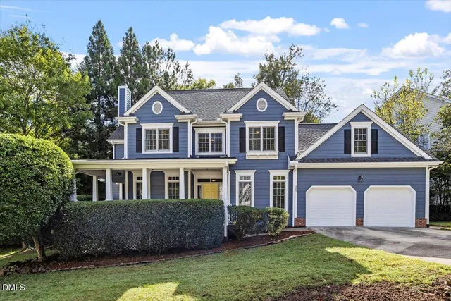 a front view of a house with a garden and yard