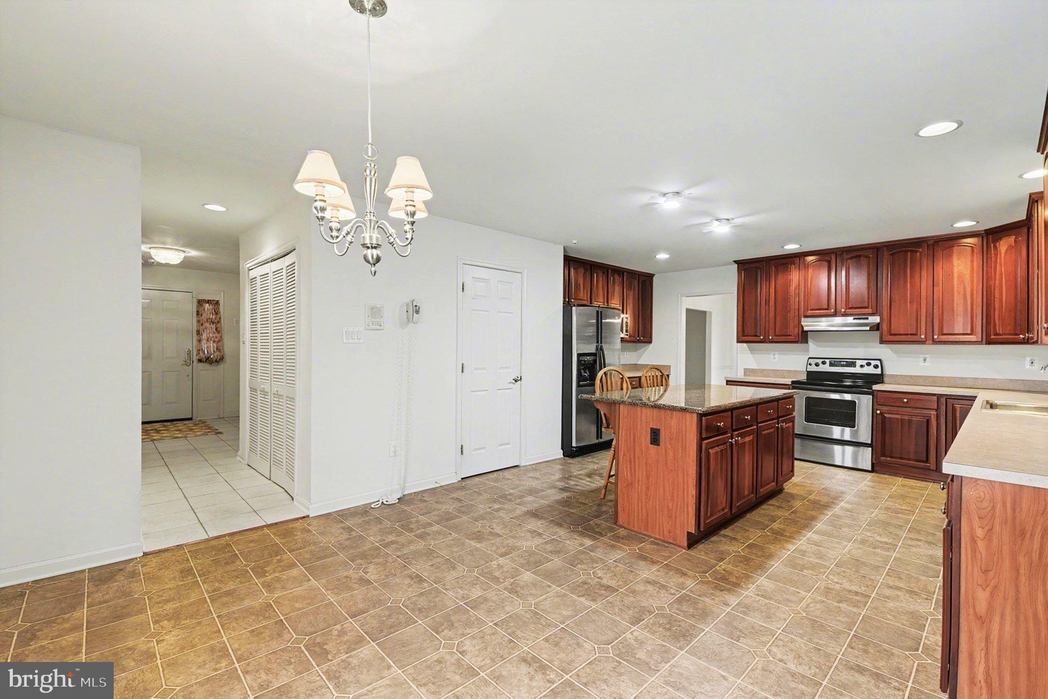 1645 Timber Summit Drive Westminster, MD 21157 - Photo 14 of 52 a large kitchen with stainless steel appliances kitchen island granite countertop a refrigerator and a sink