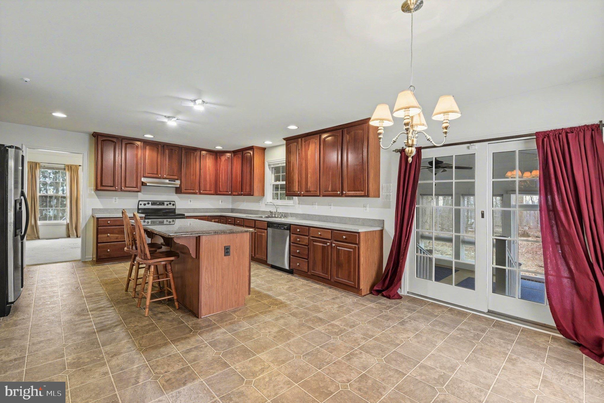 1645 Timber Summit Drive Westminster, MD 21157 - Photo 15 of 52 a open kitchen with stainless steel appliances granite countertop a stove refrigerator a oven a dining table and chairs