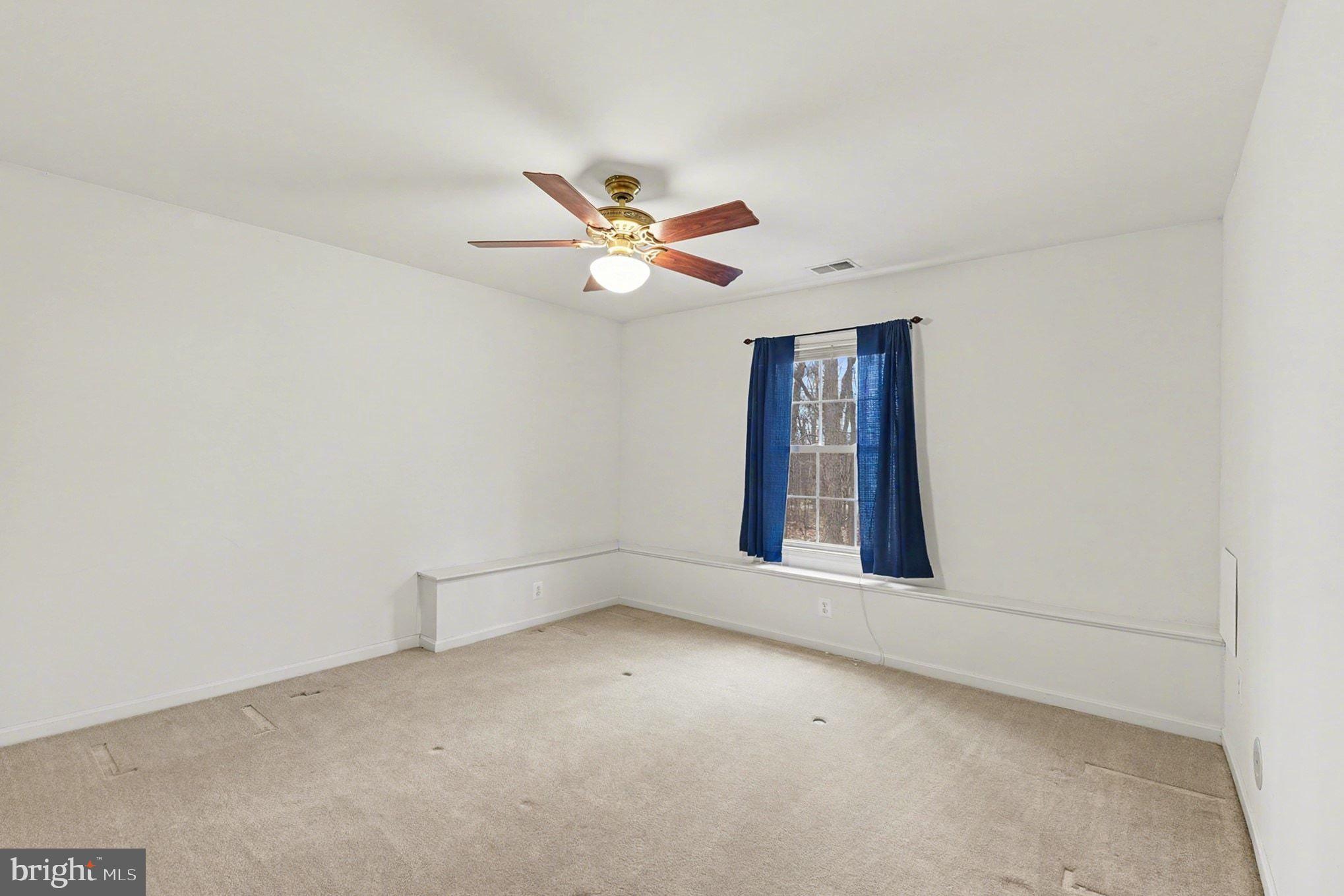 1645 Timber Summit Drive Westminster, MD 21157 - Photo 36 of 52 an empty room with a window and a ceiling fan