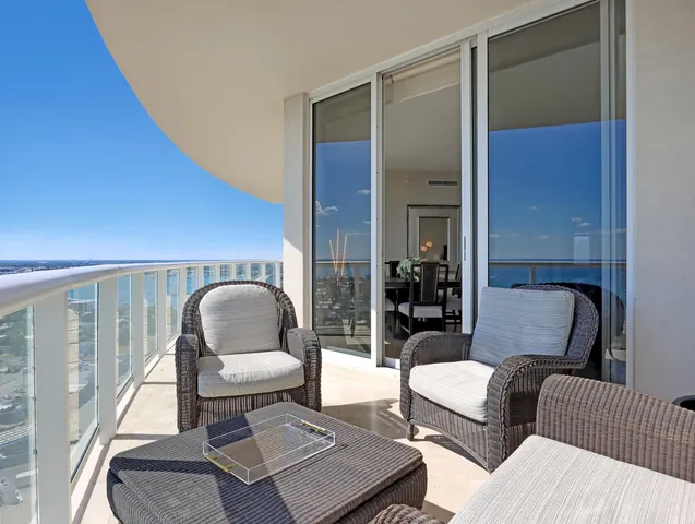 a living room with furniture and floor to ceiling windows
