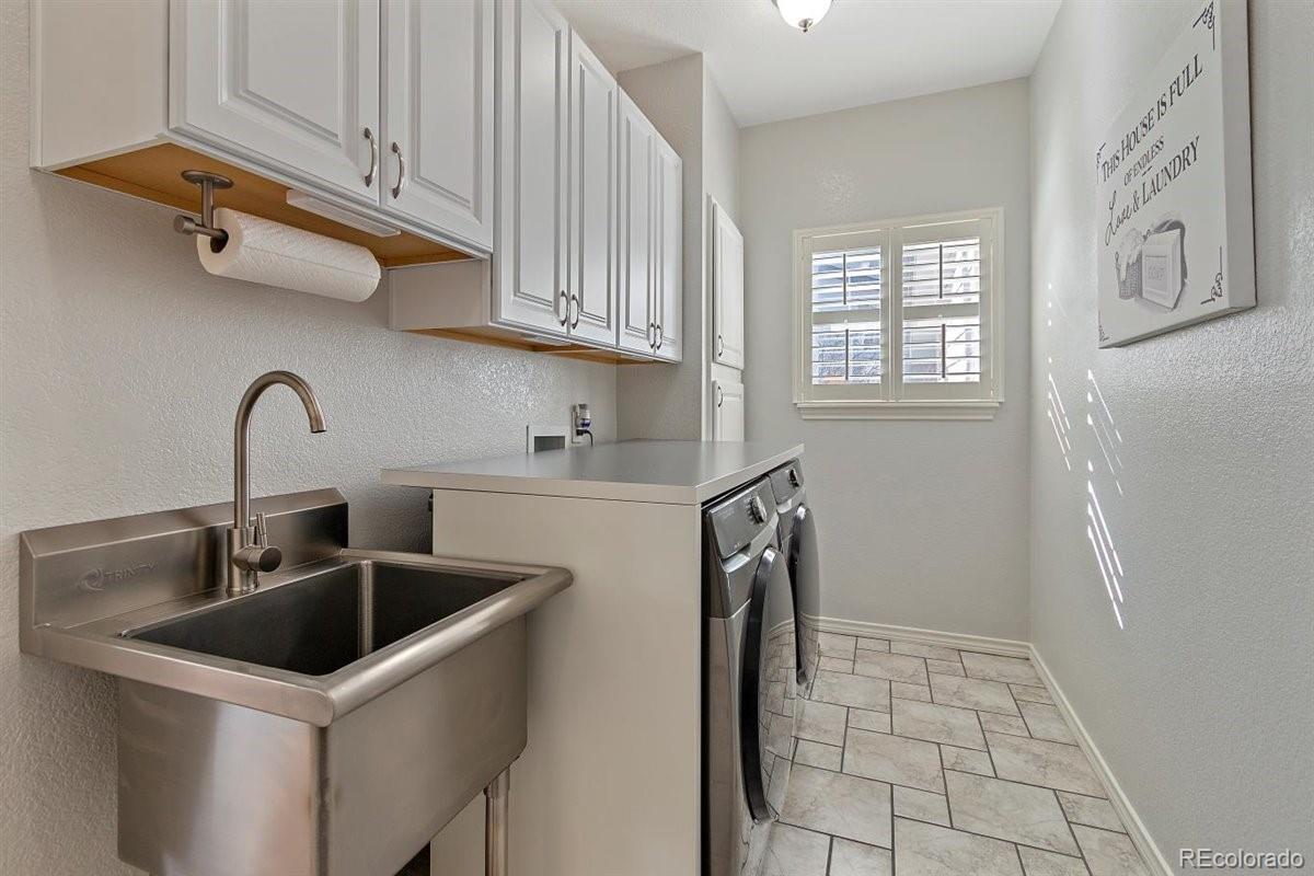 2290 Crestmont Lane Highlands Ranch, CO 80126 - Photo 13 of 40 a kitchen with a sink cabinets and utility