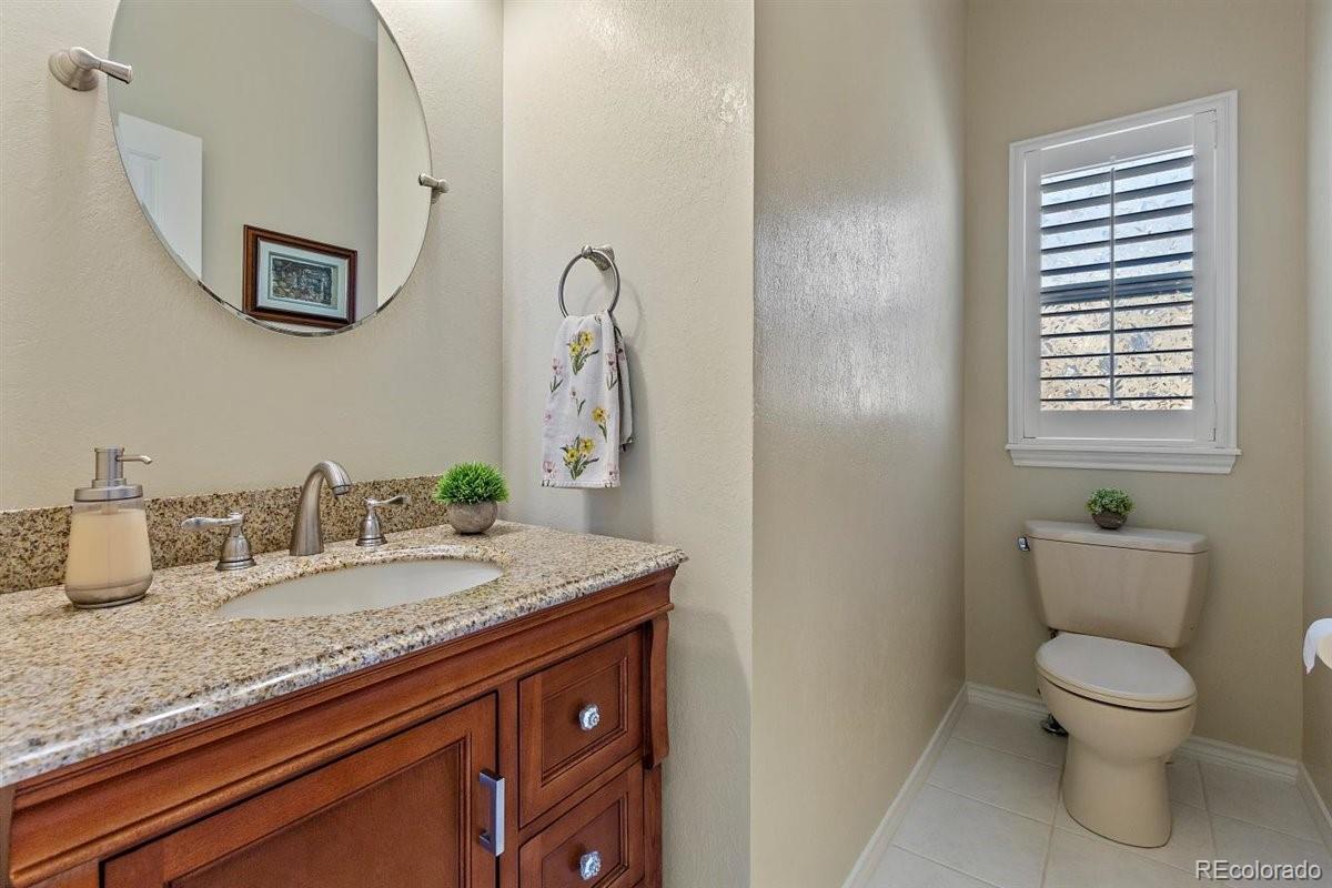 2290 Crestmont Lane Highlands Ranch, CO 80126 - Photo 16 of 40 a bathroom with a granite countertop toilet sink and mirror