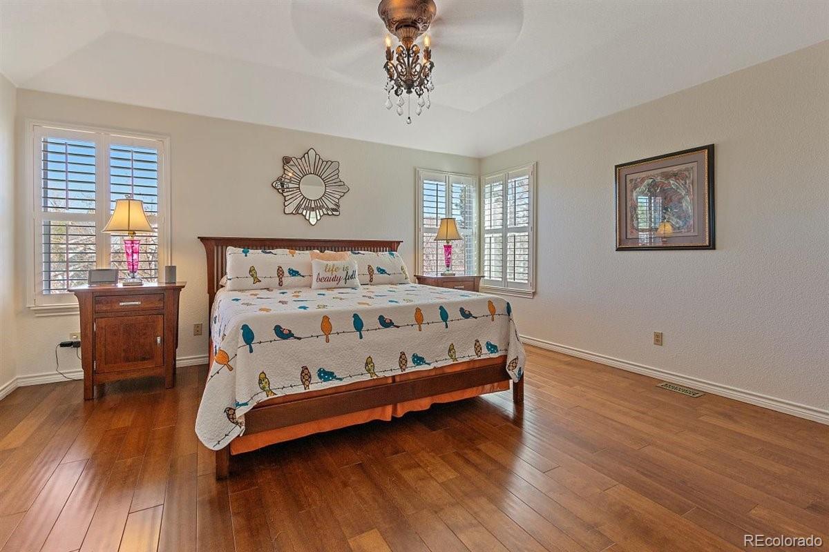 2290 Crestmont Lane Highlands Ranch, CO 80126 - Photo 18 of 40 a bedroom with a bed and wooden floor