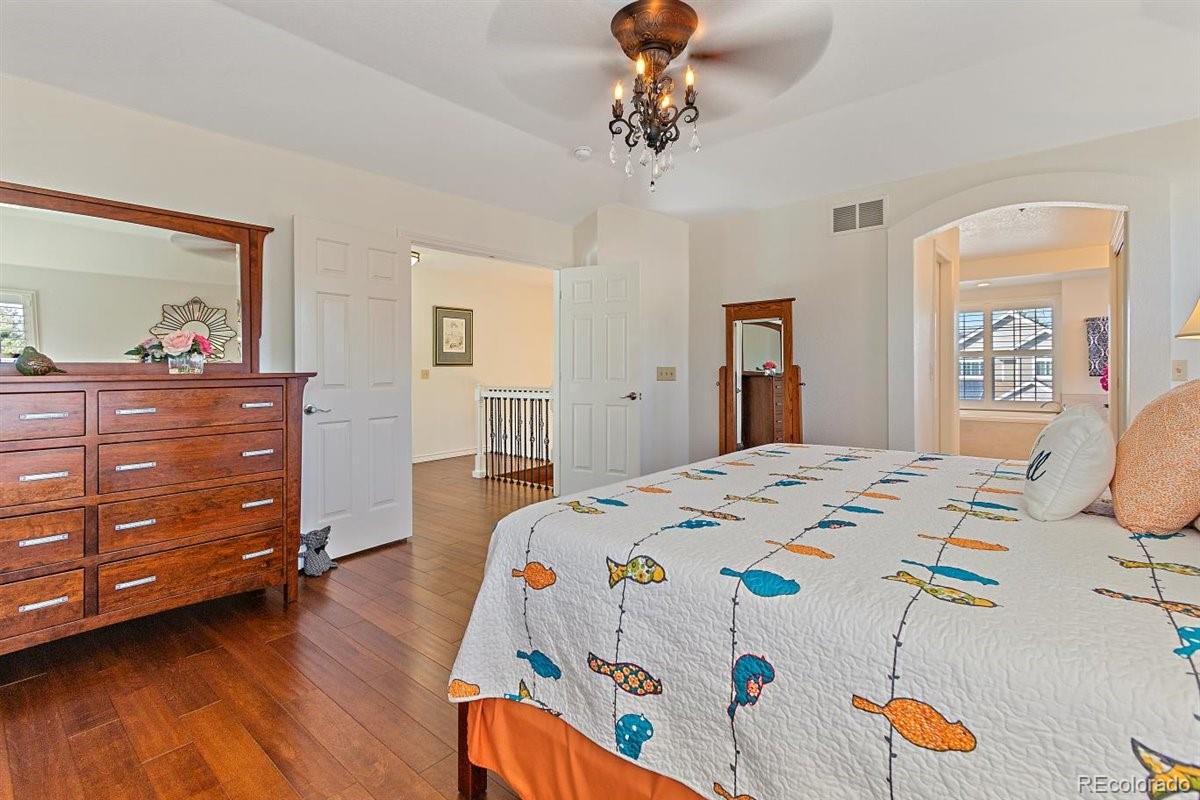 2290 Crestmont Lane Highlands Ranch, CO 80126 - Photo 19 of 40 a bedroom with a bed and wooden floor