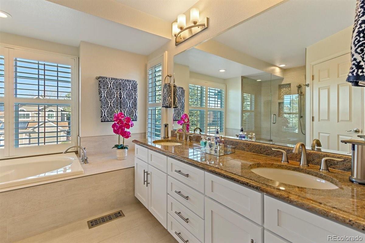 2290 Crestmont Lane Highlands Ranch, CO 80126 - Photo 21 of 40 a bathroom with double vanity sinks a faucet a chandelier and a large mirror