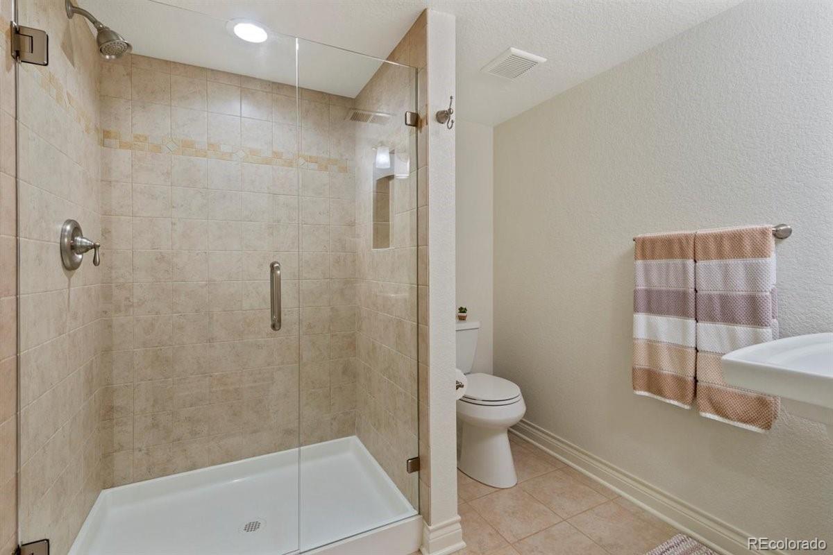2290 Crestmont Lane Highlands Ranch, CO 80126 - Photo 35 of 40 a bathroom with a shower a toilet and a shower