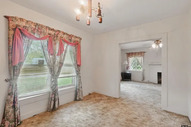 a view of empty room with window and ceiling fan