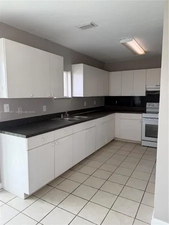 a kitchen with granite countertop a sink and cabinets