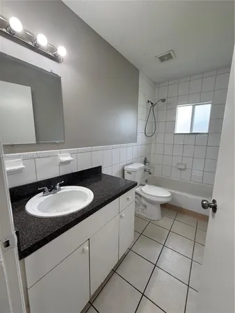 a bathroom with a double vanity sink toilet and a mirror