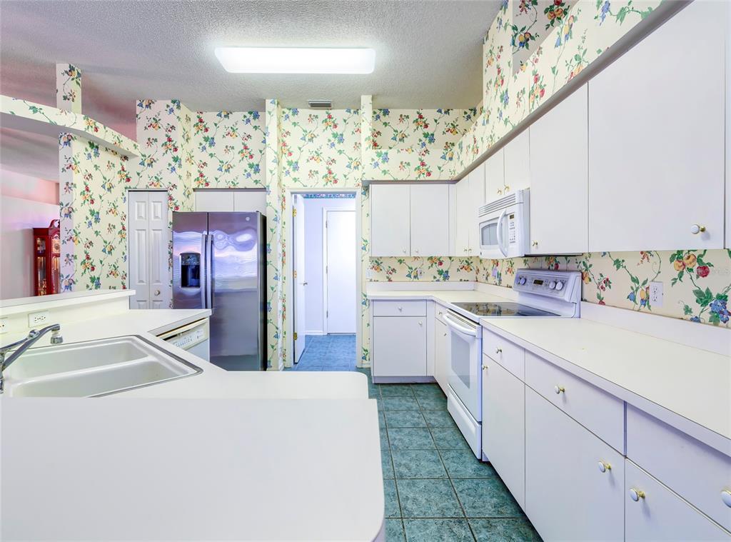 11228 Windrush Circle Hudson, FL 34667 - Photo 23 of 67 a kitchen with a sink a refrigerator and cabinets