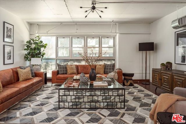 a living room with furniture a table and a large window