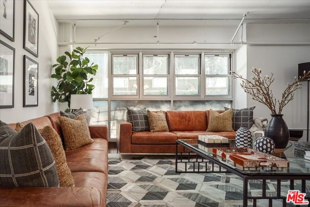 a bedroom with a bed a couch and a window with outer view