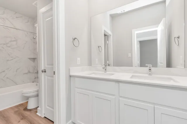 a bathroom with a double vanity sink toilet and shower