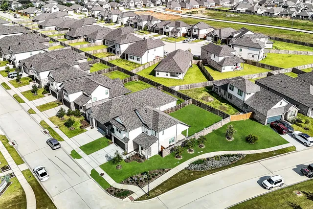 an aerial view of residential houses with outdoor space and swimming pool