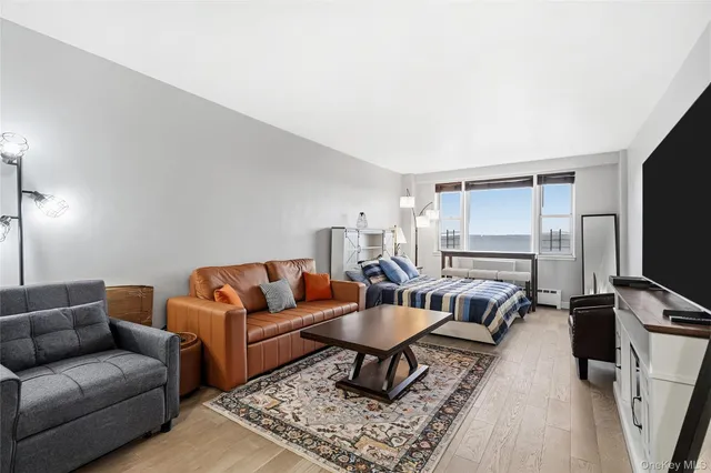 a living room with furniture a flat screen tv and a stove