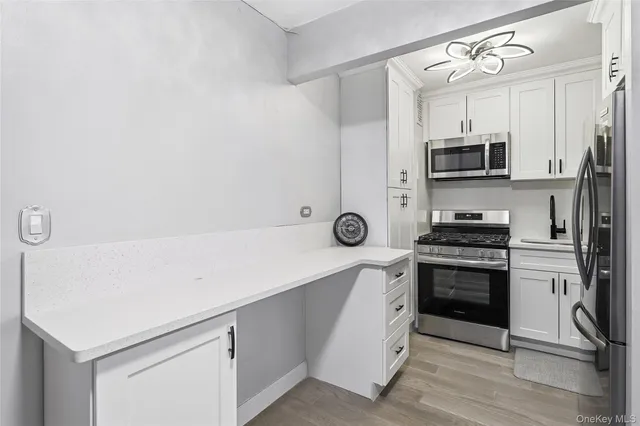 a kitchen with stainless steel appliances a stove microwave and refrigerator