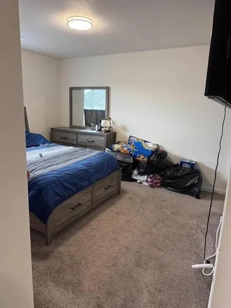 a spacious bedroom with a bed and a flat screen tv