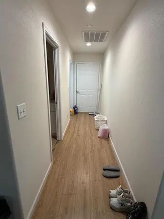a view of a hallway with wooden floor