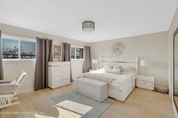 a bedroom with a large bed and a chandelier