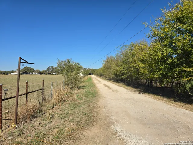 a view of a yard with wooden fence
