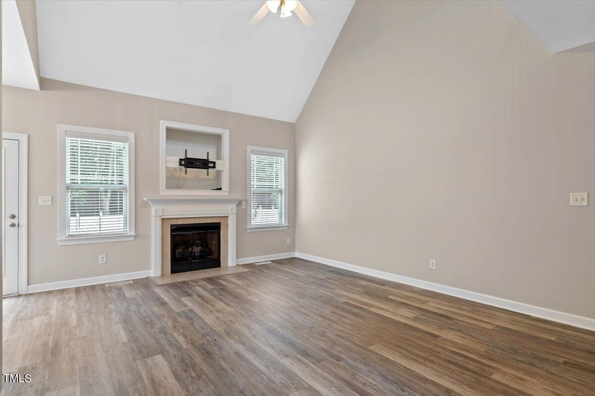 134 Blessed Lane Angier, NC 27501 - Photo 11 of 41 wooden floor fireplace and windows in an empty room
