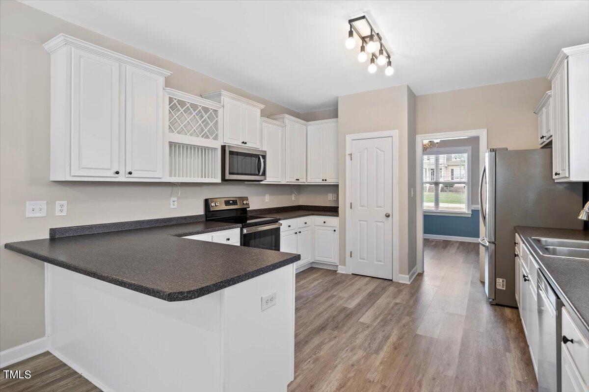 134 Blessed Lane Angier, NC 27501 - Photo 5 of 41 a kitchen with stainless steel appliances granite countertop a refrigerator a stove top oven a sink dishwasher and a refrigerator with wooden floor
