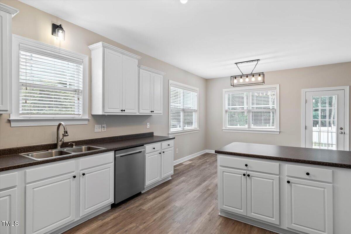 134 Blessed Lane Angier, NC 27501 - Photo 8 of 41 a kitchen with granite countertop white cabinets white appliances wooden floor and a window