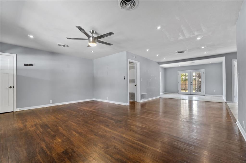 2105 Fortview Road Austin, TX 78704 - Photo 8 of 37 Warm wood flooring extends throughout this generous living space, anchored by a modern ceiling fan and recessed lighting.