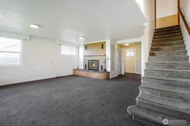 a view of an empty room with stairs and furniture