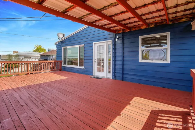 a view of a backyard with wooden floor and iron fence